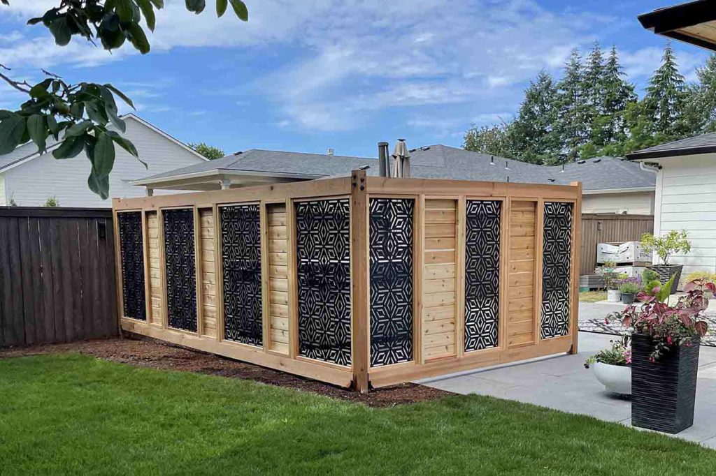 A privacy fence pergola surrounding a hot tub in the backyard