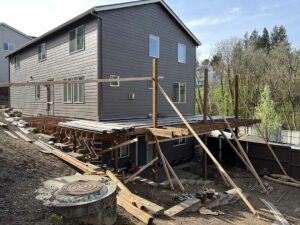 Brown house with partially completed deck on two sides.