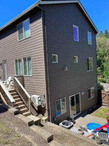 Brown house with small deck on one side with a stairway.